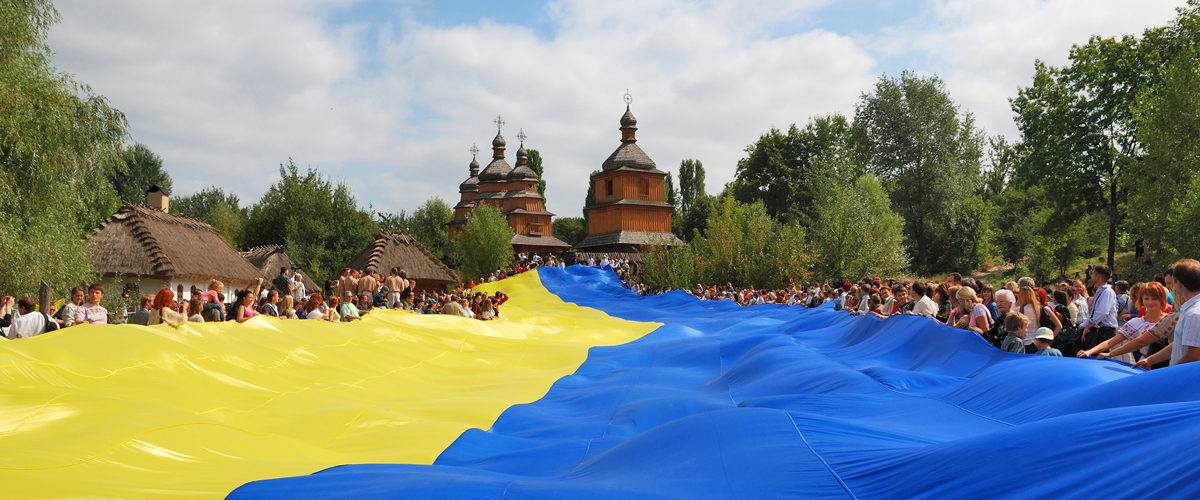 Celebración con multitud de gente sujetandop una enorme bandera de Ucrania
